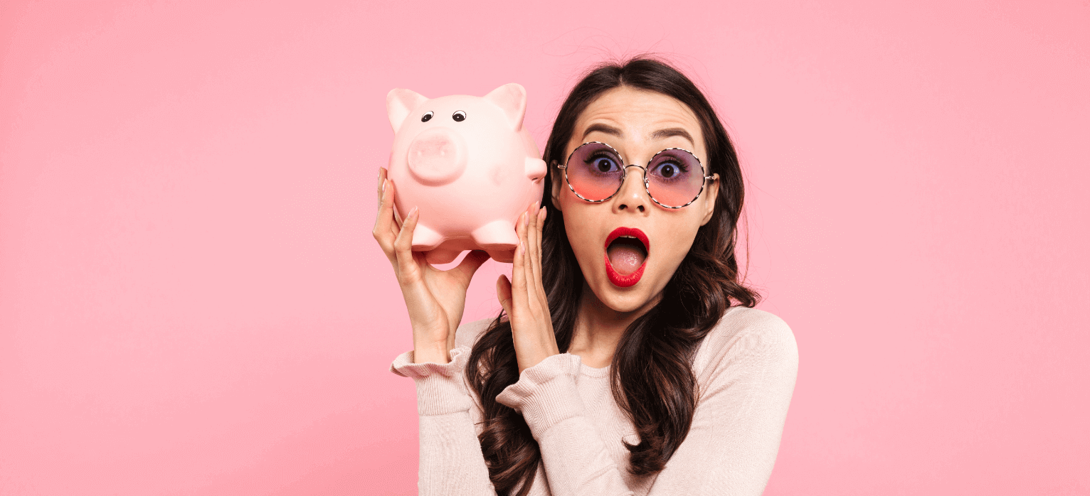 Girl wearing sunglasses and a sweater holding a pink piggy bank