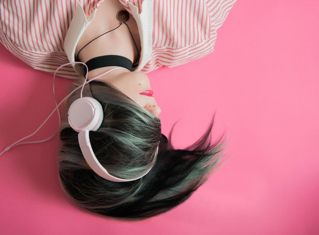woman listening to music through headphones while thinking of payday loans no credit check instant approval