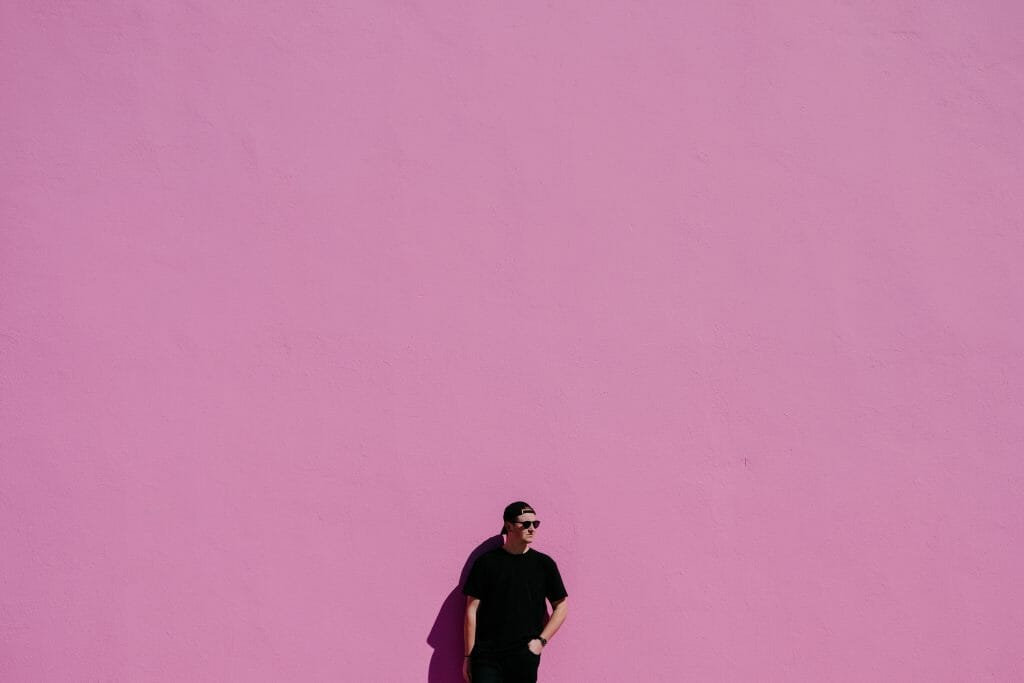 Man standing against pink wall thinking about no paperwork loans