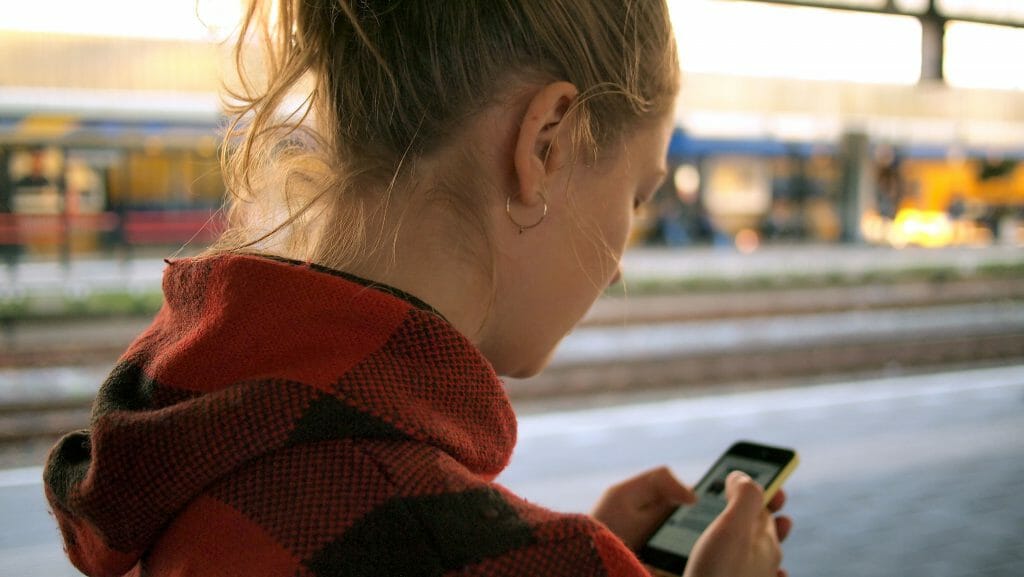 Woman on iPhone browsing for instant cash loans online