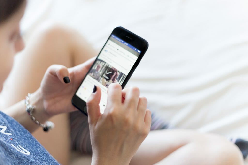 Woman using iPhone to browse for micro loans online