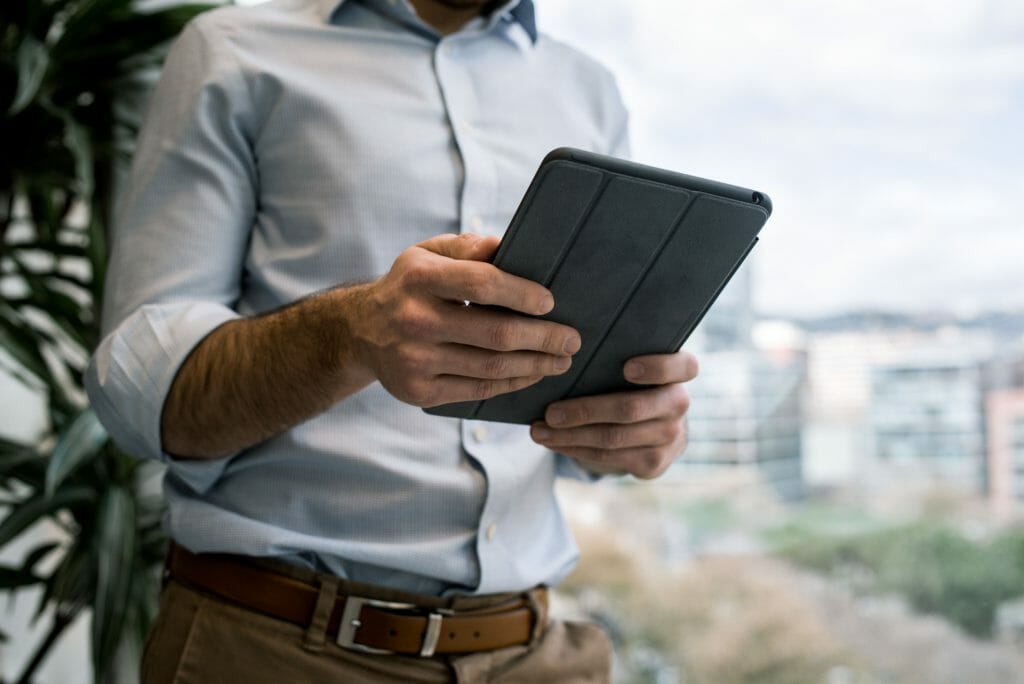 Man in blue shirt using tablet to browse for same day cash loans