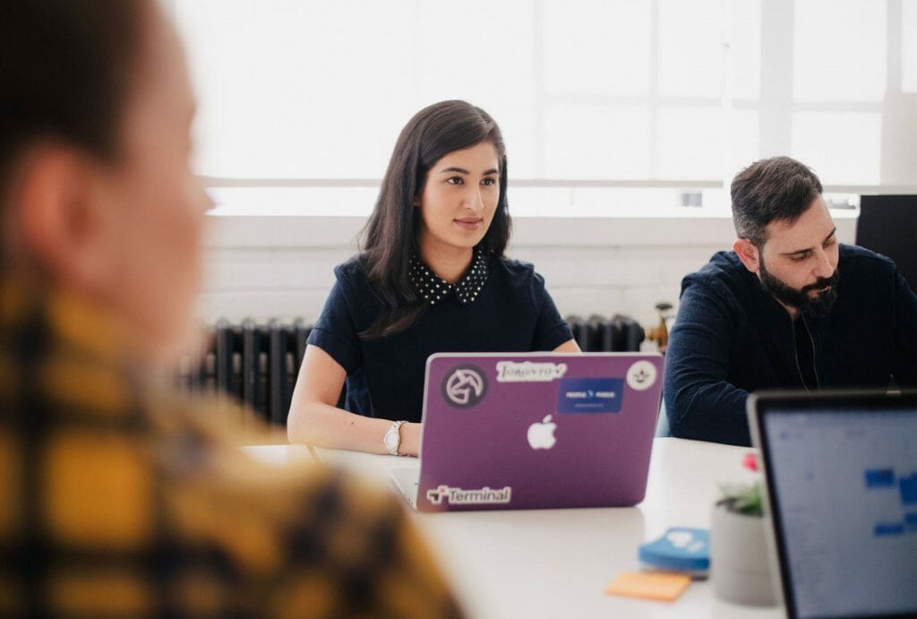 Team sitting in office looking for small personal loans online