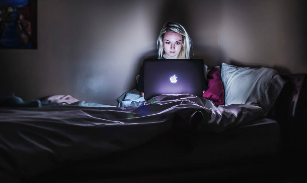 Woman in bed on laptop she need cash now