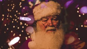 Man dressed as Santa Claus talking about Christmas budget
