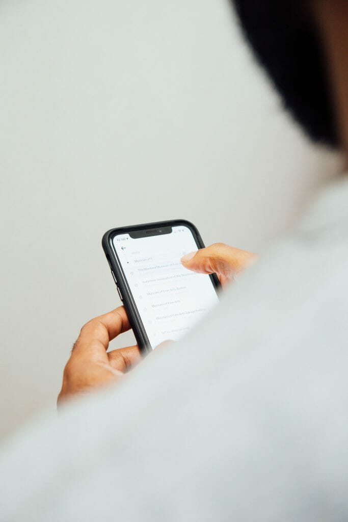 Over the shoulder shot of man with iPhone searching for payday loans for bad credit instant approval