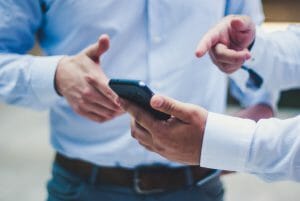 Instant loan approval businessmen pointing at phone
