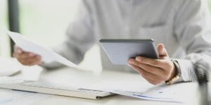 Personal loan comparison man holding tablet and paper