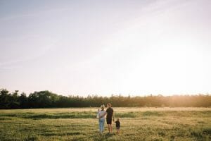 A happy family in a field who are covered by life insurance