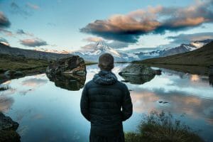 Man staring at clear blue lake after applying for $2,100 loan